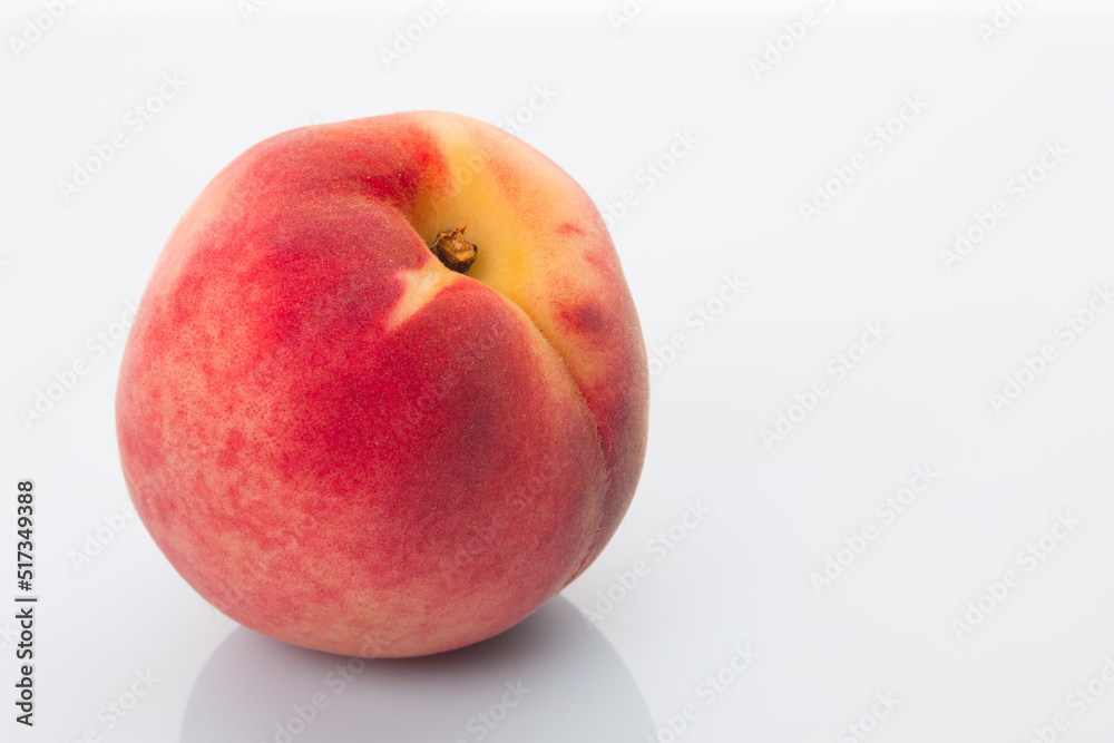 A bright red peach on a white background A bright red peach on a white background