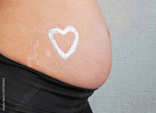 Wallpaper Mural Stretch marks on the skin during pregnancy. Skin care during pregnancy concept. Heart shape created from cream.  Torontodigital.ca