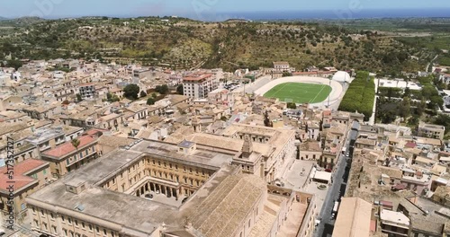 Zoom in aerial view of Noto, the ancient historical baroque Sicilian city in Italy, crossing a soccer field stadium. photo