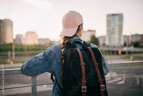 Tourist admires the overview of the sights of the city. Woman with backpack enjoy beautiful city view, traveler mock up top of the city.