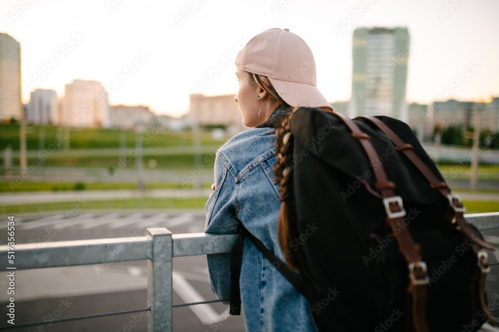 Tourist admires the overview of the sights of the city. Woman with backpack enjoy beautiful city view, traveler mock up top of the city.