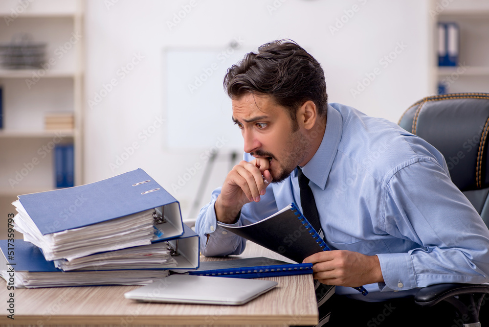 Fototapeta premium Young male employee working in the office