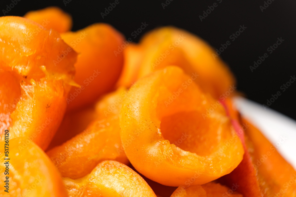 Juicy apricot slices on a black background, side view. Juicy apricot slices on a black background, side view.