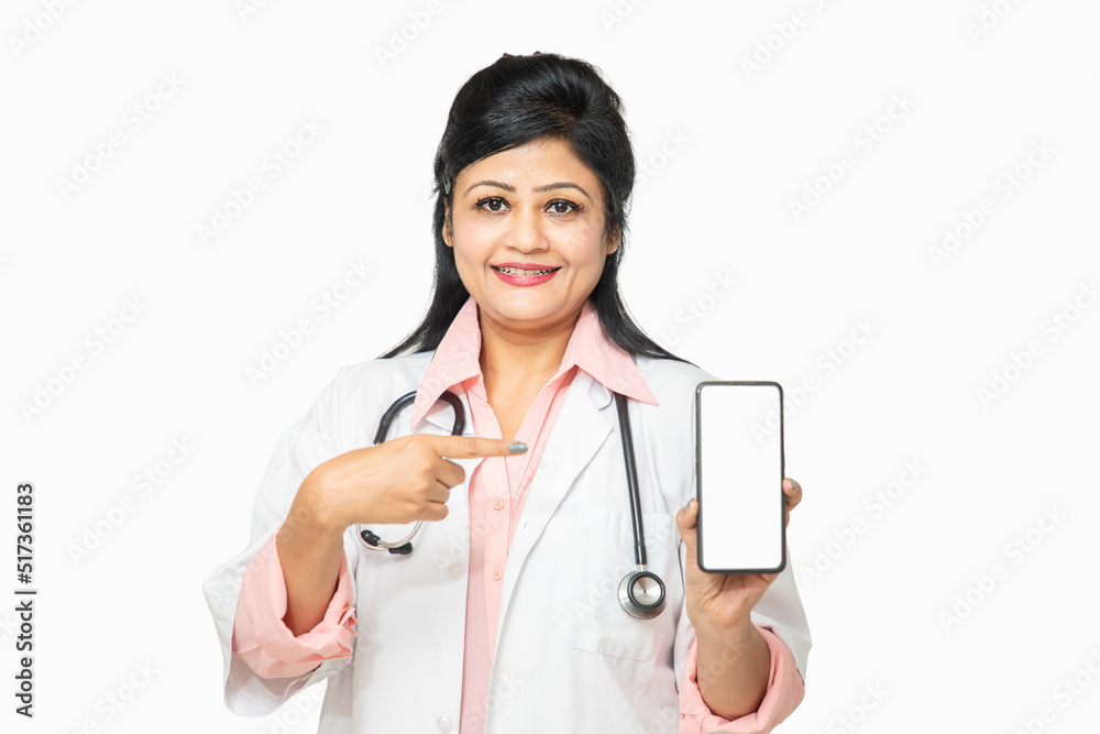 Portrait happy beautiful indian female doctor wearing stethoscope holding smartphone with white or blank screen, promoting app, advertisement, isolated. healthcare and medical concept. Portrait happy beautiful indian female doctor wearing stethoscope holding smartphone with white or blank screen, promoting app, advertisement, isolated. healthcare and medical concept.