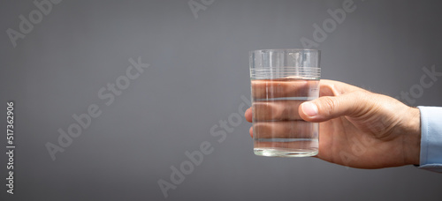 Caucasian businessman holding glass of water.
