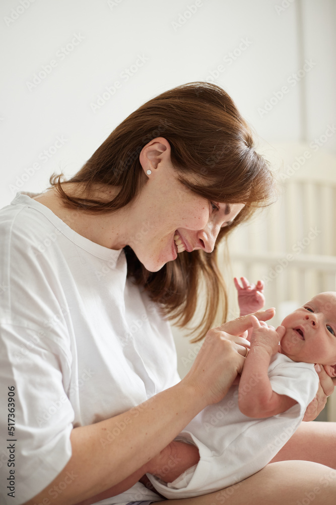 Mother holding her newborn baby. Home portrait of newborn baby and mother. Enjoying time together Mother holding her newborn baby. Home portrait of newborn baby and mother. Enjoying time together