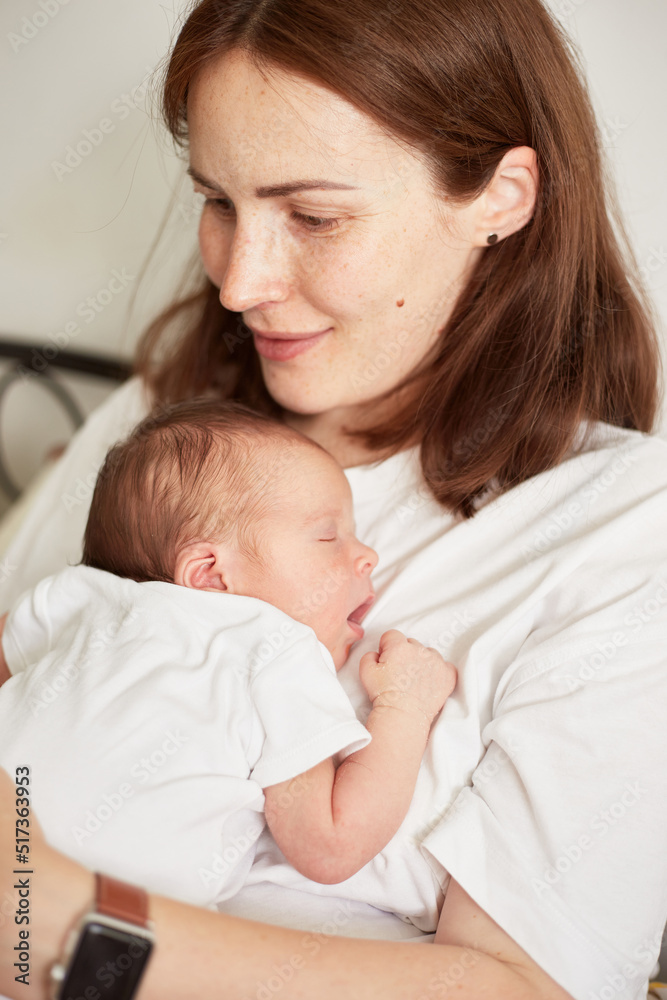 Mother holding her newborn baby. Home portrait of newborn baby and mother. Enjoying time together Mother holding her newborn baby. Home portrait of newborn baby and mother. Enjoying time together