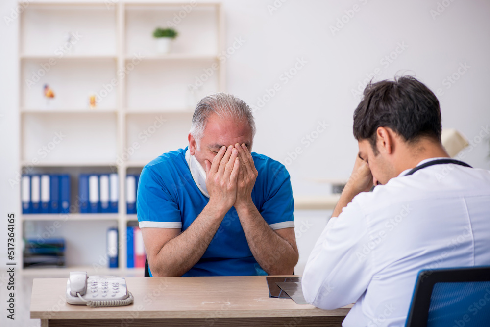 Old neck injured male patient visiting young male doctor Old neck injured male patient visiting young male doctor