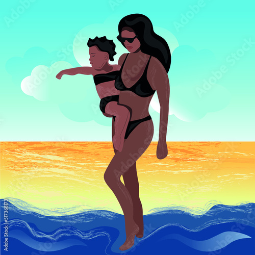 A brunette girl in a black swimsuit bikini and in black eyepieces with a child in a black swimsuit in her arms, like going into the sea, behind the beach with sand and blue sky with white-blue haze.
