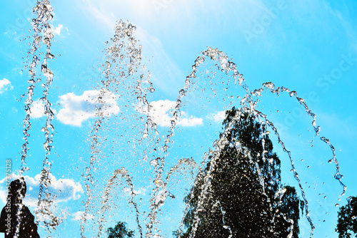 close-up water jet fountain against blue sky