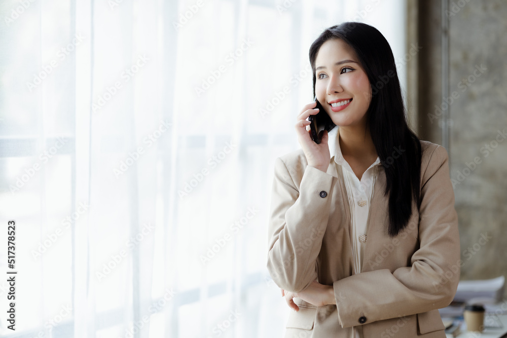 Beautiful Asian woman executives, business executives, marketing executives are talking on the phone with customers to contact the company for marketing. Marketing management concept. Beautiful Asian woman executives, business executives, marketing executives are talking on the phone with customers to contact the company for marketing. Marketing management concept.