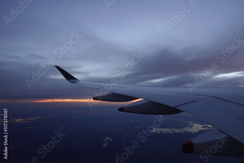 Wing of aircraft flying above the clouds