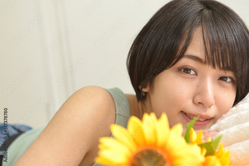 ヒマワリと室内でくつろぐキャミソール姿の若い女性のポートレート ヒマワリと室内でくつろぐキャミソール姿の若い女性のポートレート