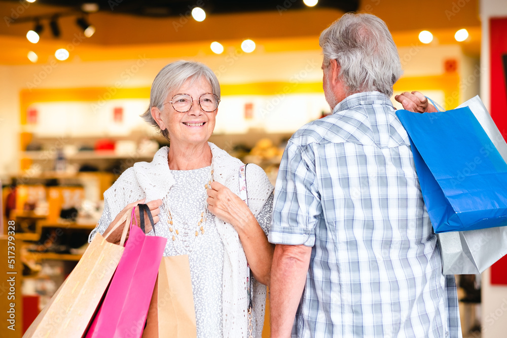 Happy senior couple carrying shopping bags enjoying shopping, consumerism sales customer shopping concept