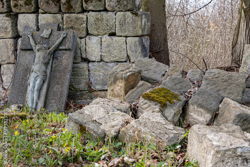 Slika na platnu A demolished stone wall with a damaged tombstone in a cemetery