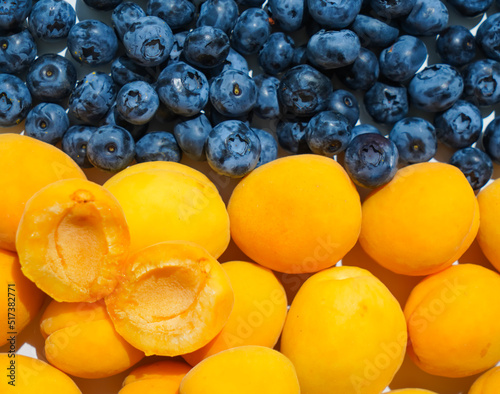 Ripe yellow apricots and blue blueberries, close-up. Yellow-blue appetizing tasty fruits of Ukraine, harvest in the shape of a flag.