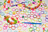 Multi-colored rubber bands for children's creativity lie on a white.