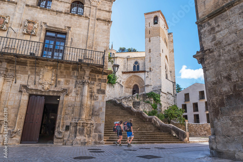 Way of St. James. Two pilgrims passing by the Church of San Pedro de la Rúa. Estella. photo