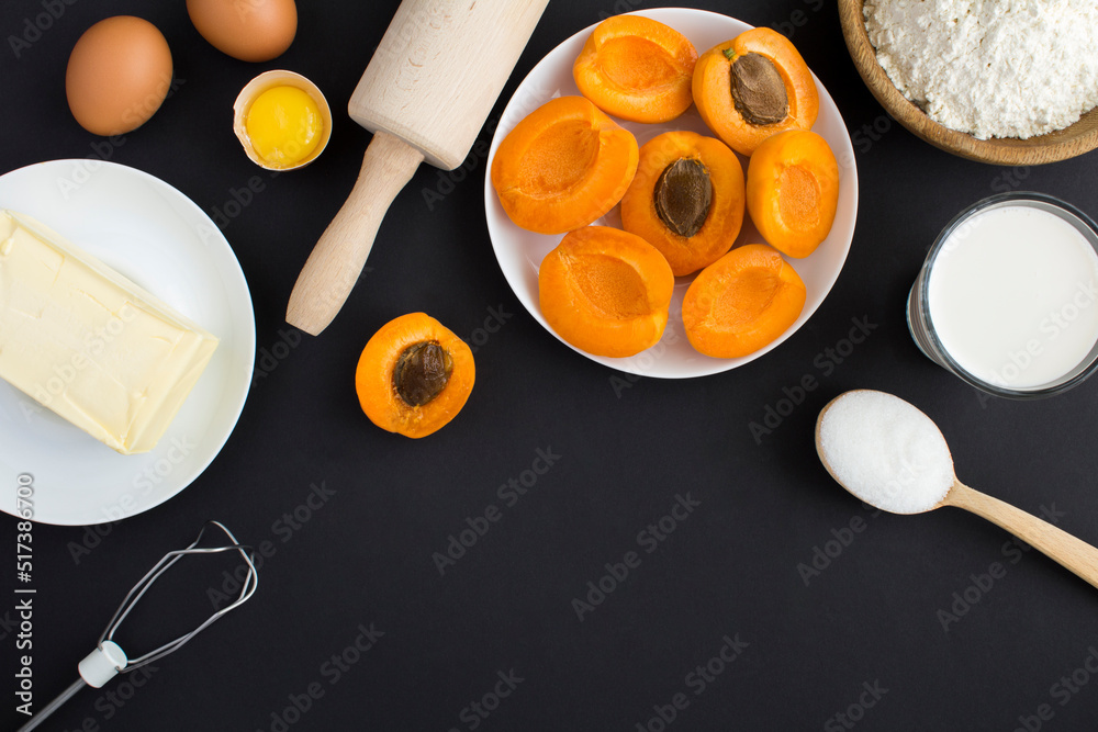 Top view of ingredients for making apricot pie or cake on the black background. Copy space. Top view of ingredients for making apricot pie or cake on the black background. Copy space.