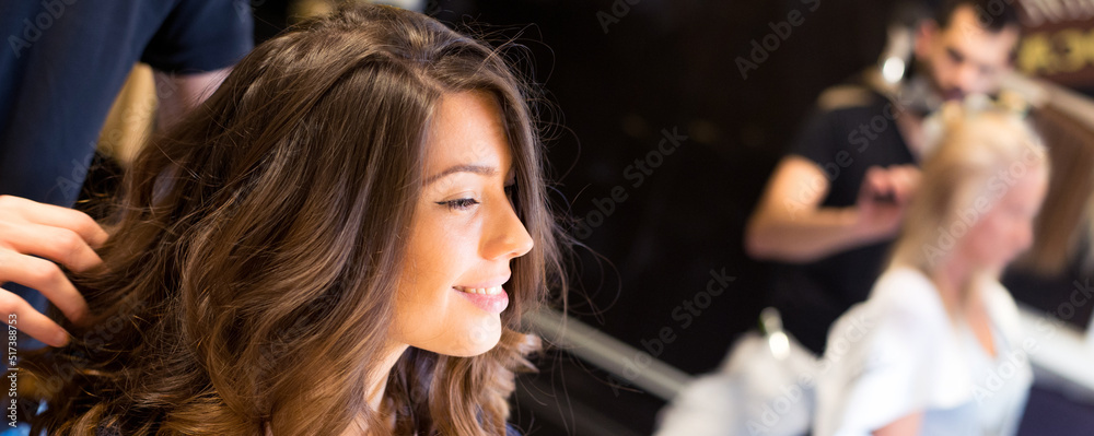Young woman getting new hairstyle from hairdresser in the modern hair salon	