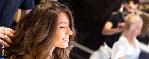 Young woman getting new hairstyle from hairdresser in the modern hair salon 