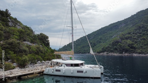 Catamaran parked in a small port entry of Croatian bay