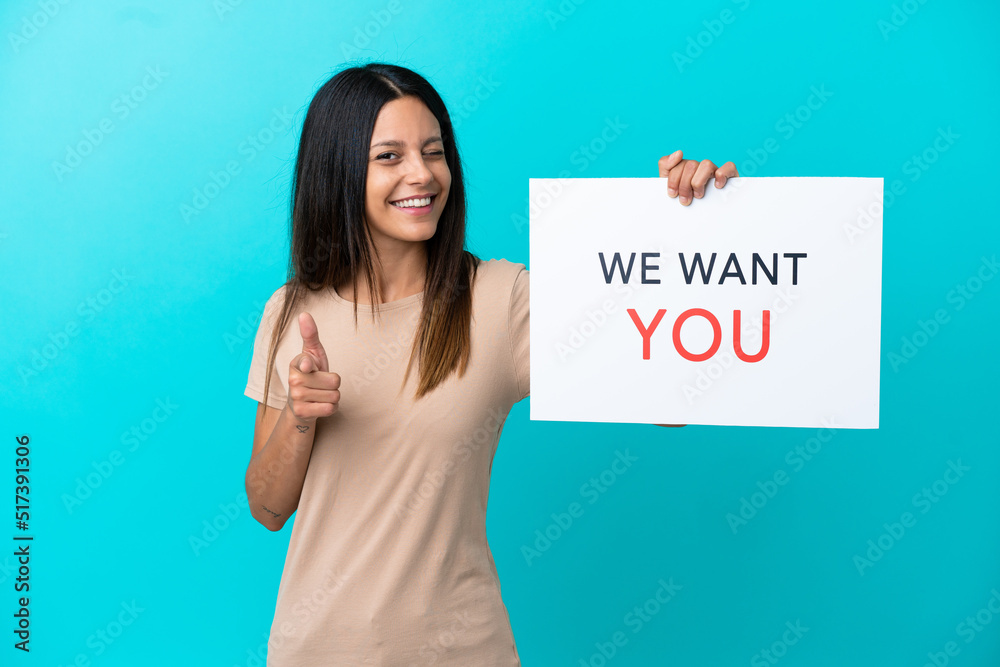 Young woman over isolated background holding We Want You board and pointing to the front Young woman over isolated background holding We Want You board and pointing to the front