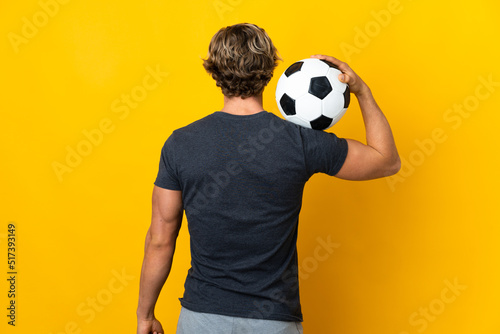 Fototapeta Naklejka Na Ścianę i Meble -  English man over isolated yellow background with soccer ball