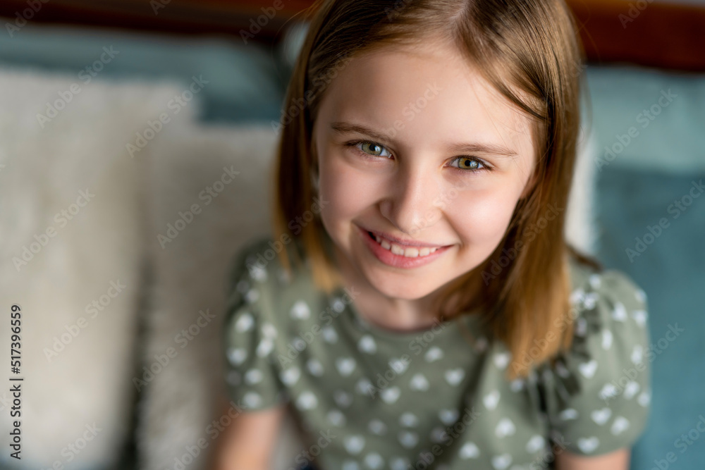 Closeup portrait og cute preteen kid girl looking at the camera and smiling. Little schoolgirl model with pretty face in the bedroom Closeup portrait og cute preteen kid girl looking at the camera and smiling. Little schoolgirl model with pretty face in the bedroom