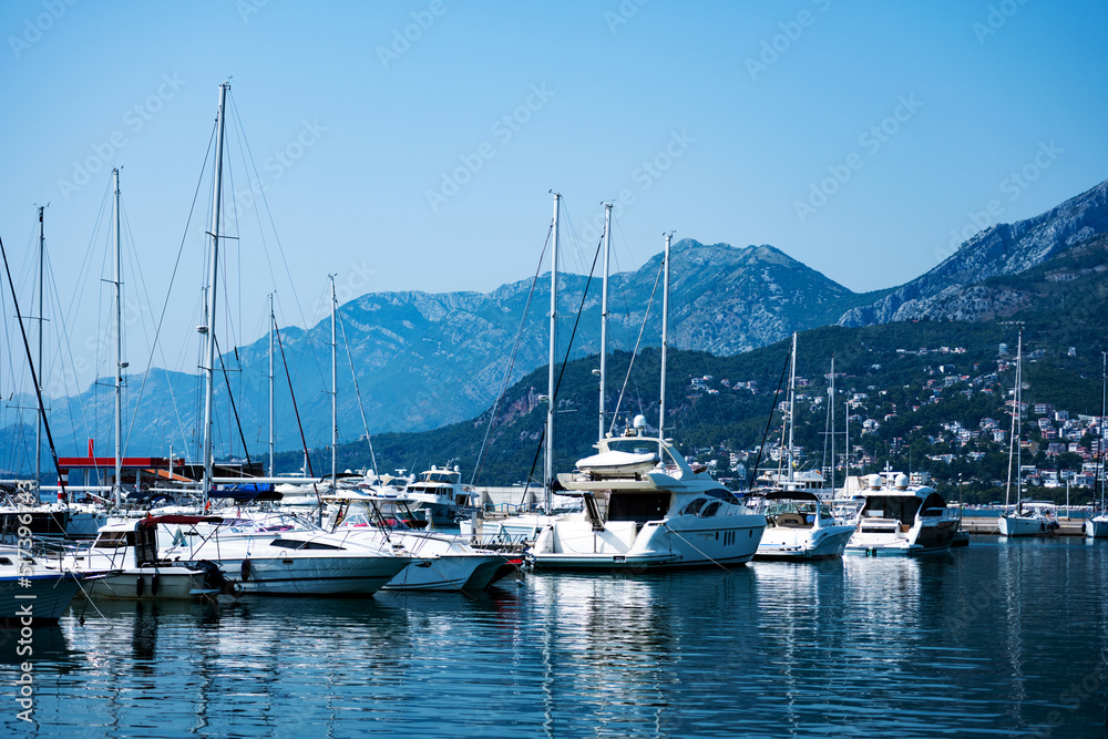 Luxury yachts port in Montenegro with mountains and city view. Boats pier in Adriatic sea with beautiful Mediterranean nature