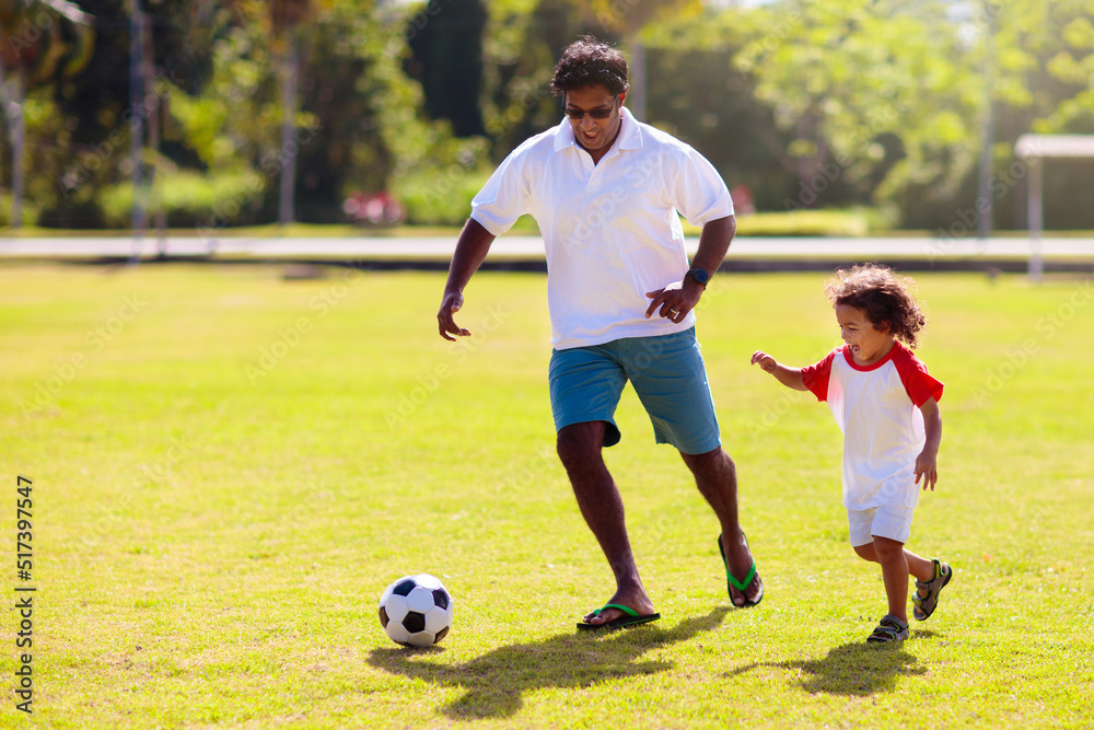 Father and son play football. Young active family. Father and son play football. Young active family.