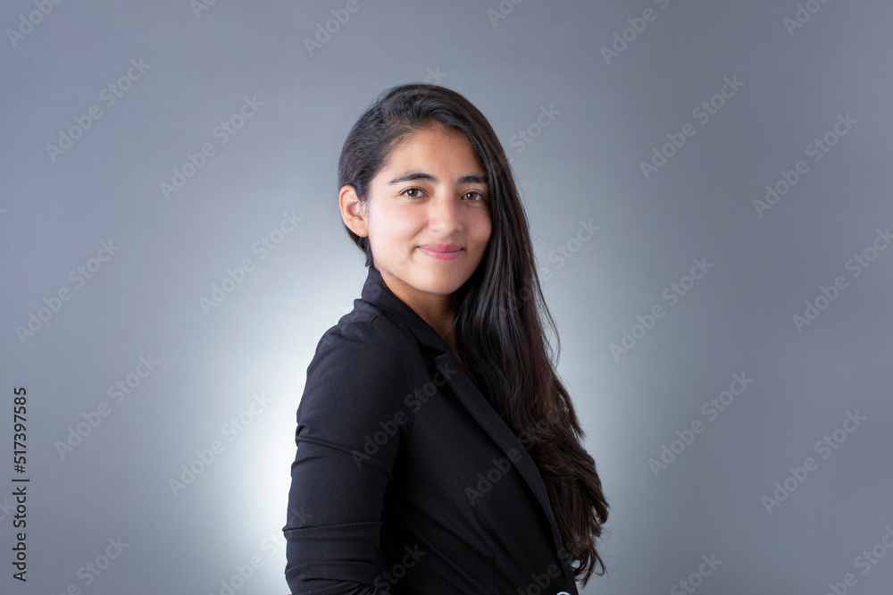 mexican woman with black blazer smiling looking at the camera and gray background mexican woman with black blazer smiling looking at the camera and gray background