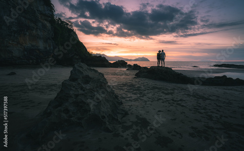 A couple watching sunset at the beach in Borneo, Malaysia.