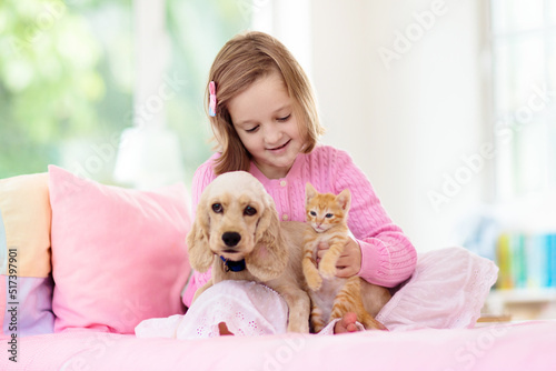 Child, dog and cat. Kids play with puppy, kitten. © famveldman