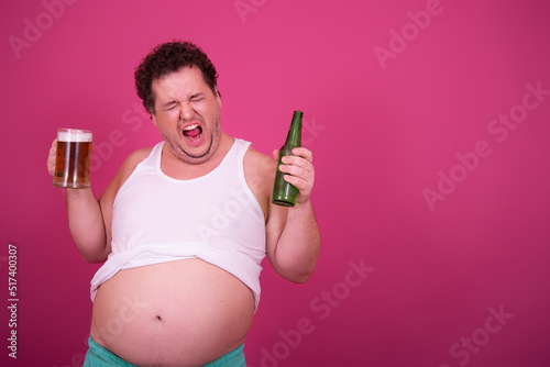 Funny fat man drinks light beer.	 photo