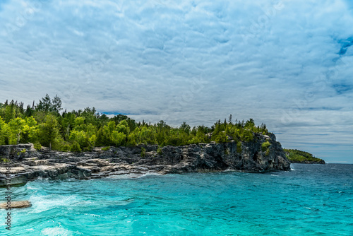 Panorama view of summer Georgian bay at Tobermory Ontario, Canada. Lake Huron and turquoise blue green transparent crystal clear water with rocky bottom formations. Indian Head Cove landscape.