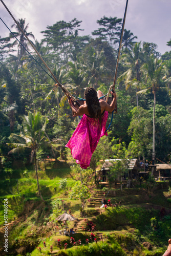 Girl on a big swing in rice fields in Bali