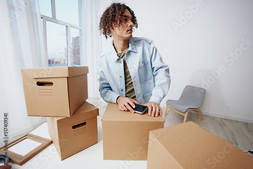 portrait of a man with a phone in hand with boxes moving Lifestyle © SHOTPRIME STUDIO