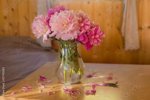 A bright window with flowers, a cup of coffee and a book on the windowsill photo