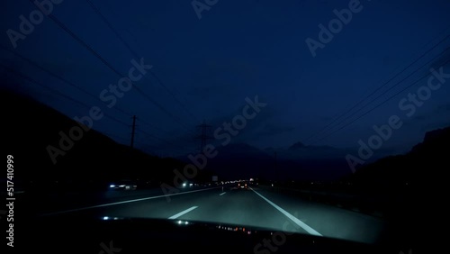 Car driving on the highway at night with beautiful mountains in front