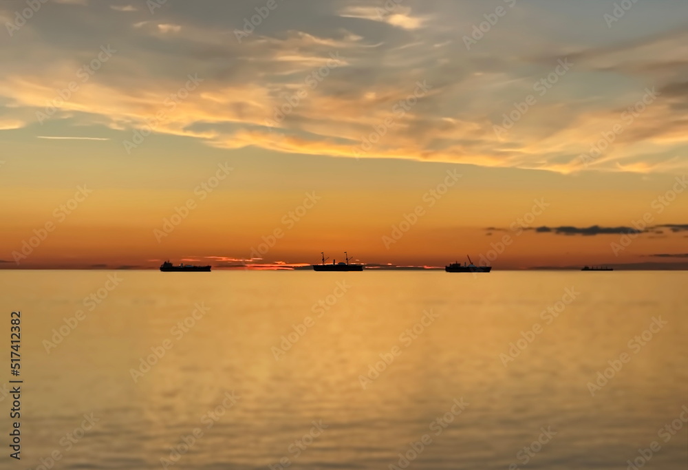 orange  gold sunset cloudy  sky at sea water reflection ship on horizon nature landscape seascape