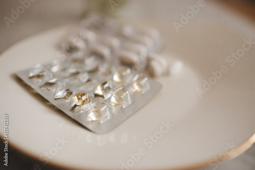 Different pills and meds in package on plate closeup. Healthcare and medical.