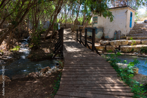 A small wooden bridge, over the flowing water of the Shokek River, the Valley of the Springs - Israel photo