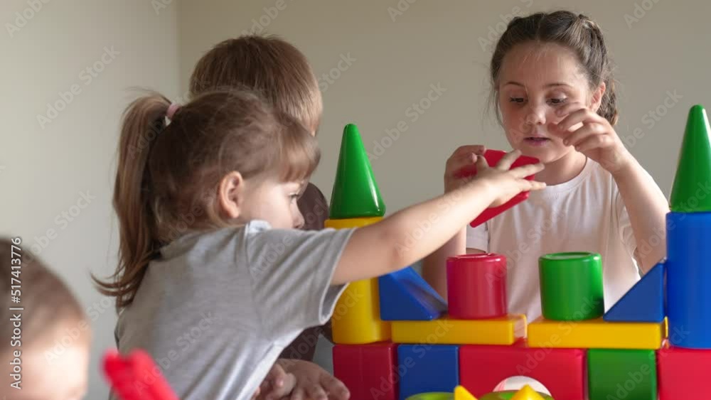 kids girl and baby boy play in kindergarten. a group of children play toys cubes and cars on the table in kindergarten indoor. happy family preschool education concept. nursery baby toddler home kids girl and baby boy play in kindergarten. a group of children play toys cubes and cars on the table in kindergarten indoor. happy family preschool education concept. nursery baby toddler home