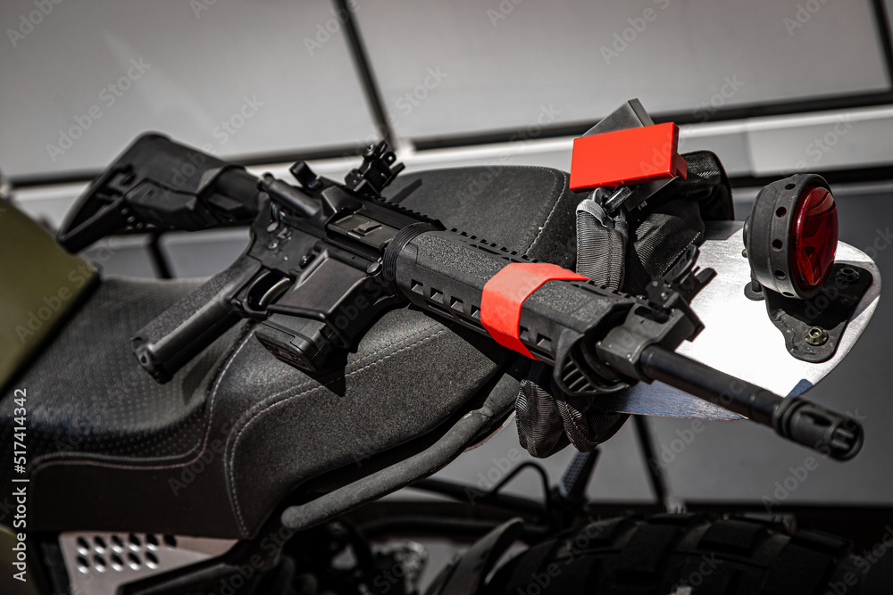 Fototapeta premium Automatic carabiner on a motorcycle. Weapons for police, special forces and the army. Automatic carbine with mechanical sights.