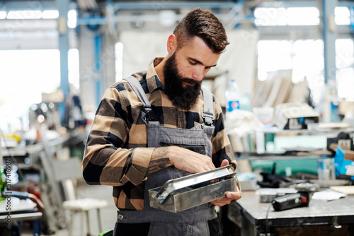 An industry worker checking on bus construction in vehicle production factory.