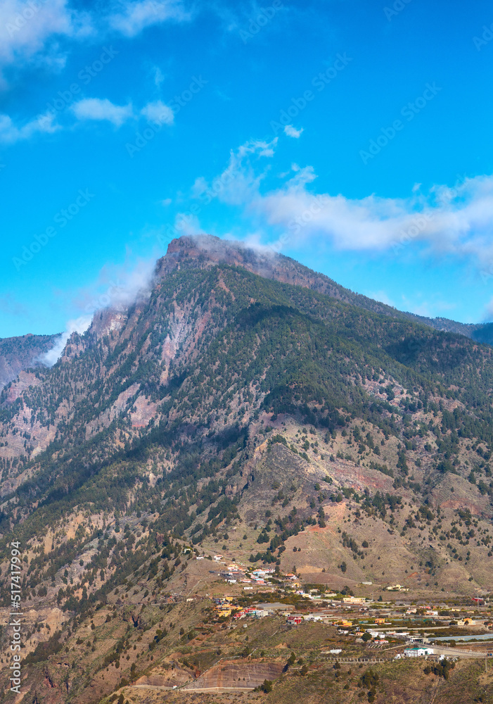 Beautiful landscape of mountain top near a small town or village. Peaceful and scenic view of a peak with a cloudy blue sky background on a summer day. A summit with lush green plants and nature Beautiful landscape of mountain top near a small town or village. Peaceful and scenic view of a peak with a cloudy blue sky background on a summer day. A summit with lush green plants and nature