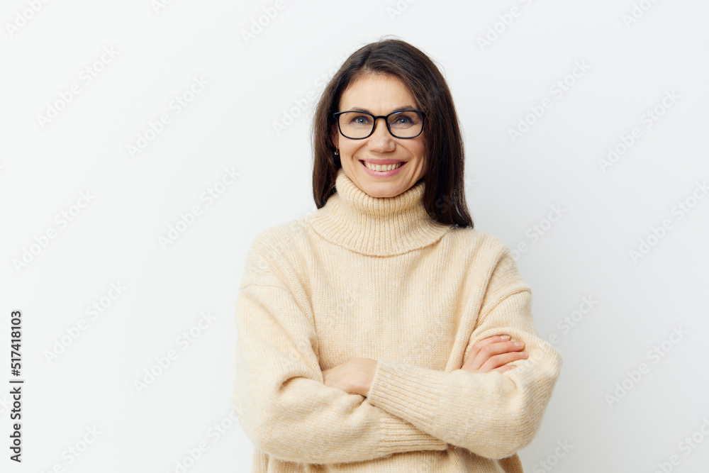 portrait of a beautiful cute woman in a beige sweater on a light background in glasses for vision with arms crossed on her chest portrait of a beautiful cute woman in a beige sweater on a light background in glasses for vision with arms crossed on her chest