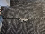 torn black carpet or rug in floor of airplane