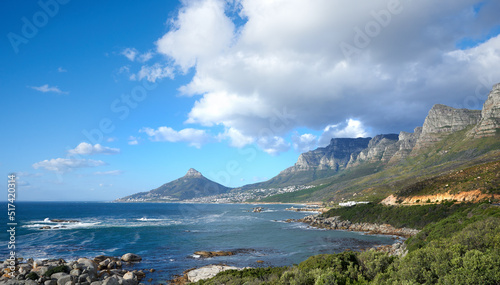 A beautiful sea landscape near a mountain with lush green plants growing outdoors in nature. Peaceful and scenic view of the ocean or beach with copy space on a summer afternoon